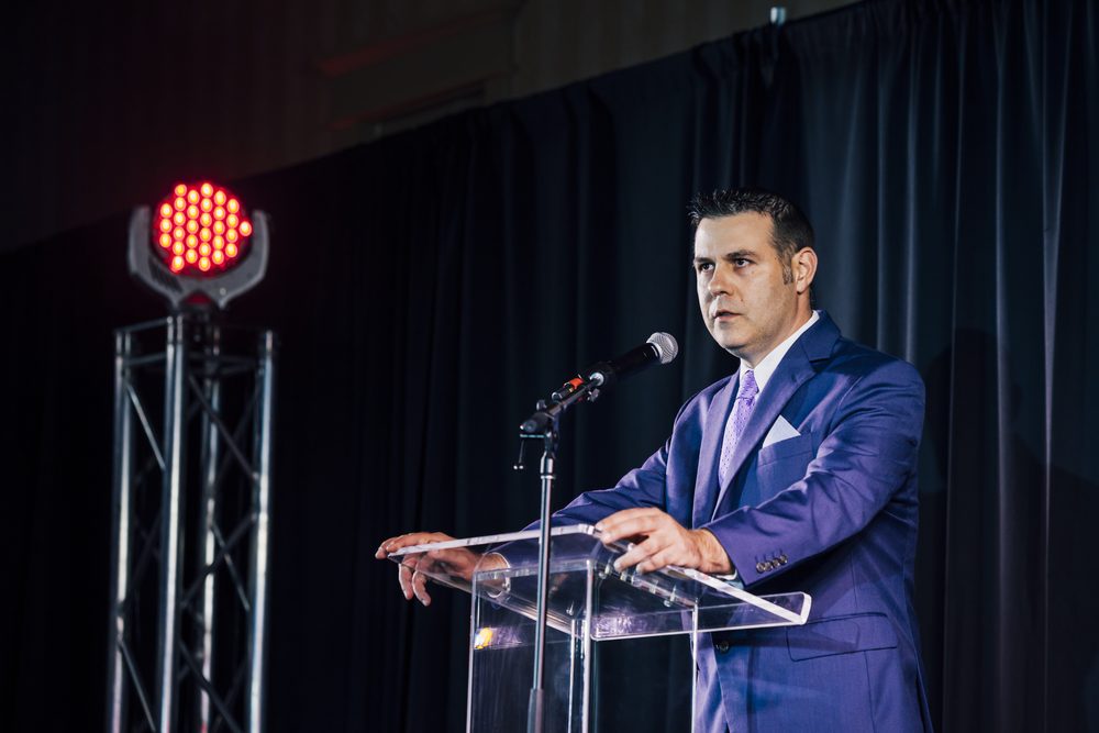 Amos McCoy speaking at a leadership conference podium